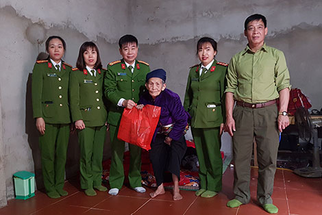 Các cán bộ tặng quà cho người già neo đơn ở xã Tự Do, Lạc Sơn.