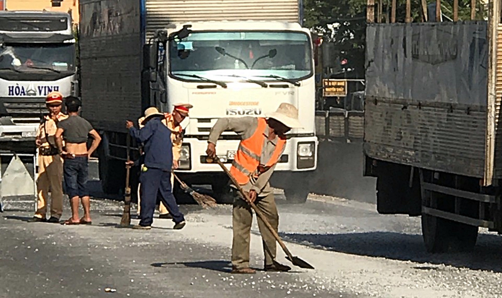CSGT “đội nắng” dọn dẹp đá dăm rơi vãi trên quốc lộ