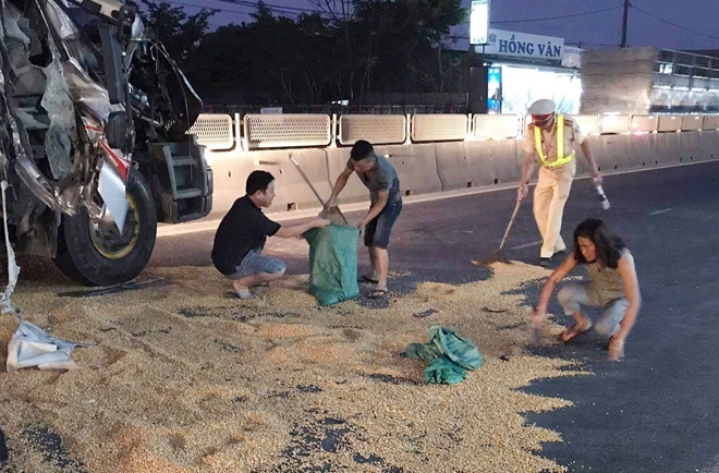 CSGT Quảng Trị giúp tài xế gom ngô rơi vãi sau tai nạn