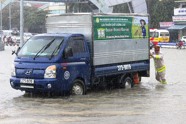 Công an TP Vinh dầm mình trong mưa rét giúp dân trên các tuyến đường ngập - Ảnh minh hoạ 4