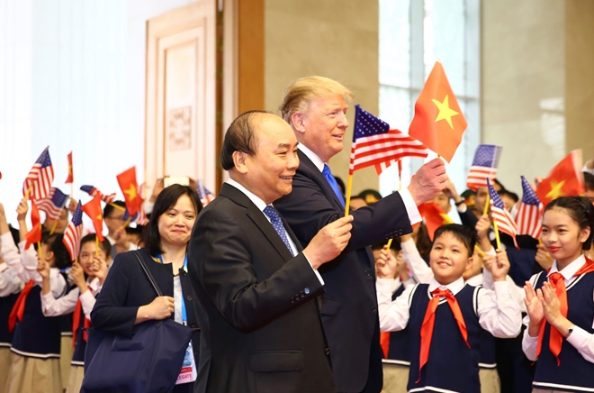 Hai nhà lãnh đạo cùng tươi cười vẫy lá cờ Việt - Mỹ trước đông đảo mọi người.