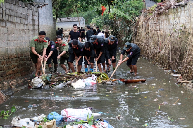 Cảnh sát cơ động giúp dân dọn dẹp vệ sinh môi trường sau lũ