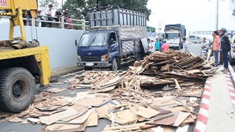 Xe tải chở hàng chục tấn gỗ phế liệu lật trong hầm chui trên Quốc lộ 1 A