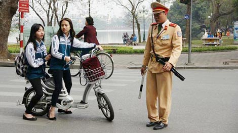 Lập chốt trước cổng trường xử phạt học sinh đầu trần đi xe máy