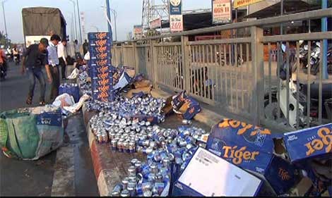 Người dân giúp thu gom hàng trăm thùng bia đổ xuống đường