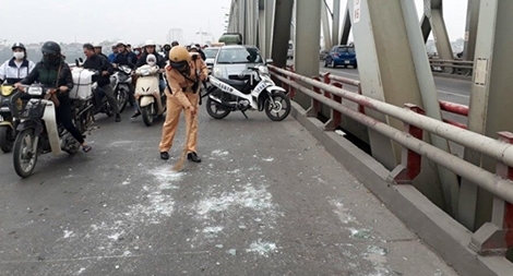 CSGT dọn thủy tinh rơi vãi trên cầu giúp ngườidân tránh nguy hiểm 