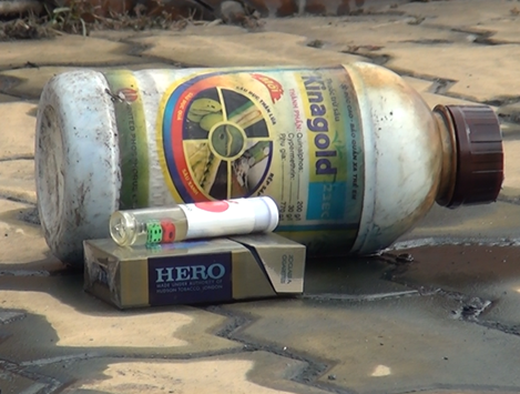 Người đàn ông bất động cạnh chai thuốc trừ sâu