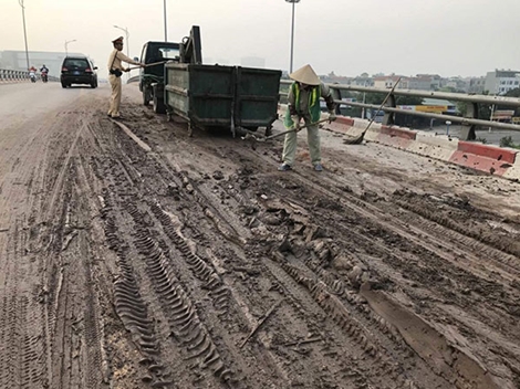 CSGT dọn bùn đất rơi vãi trên đường 