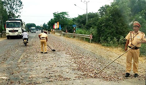 CSGT thu dọn đá dăm trên đường Quốc lộ 19