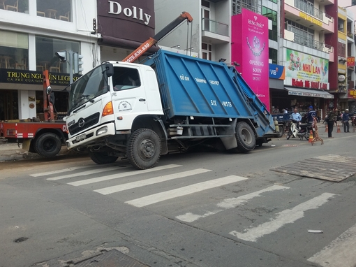 Xe rác lọt bánh xuống “hố tử thần”, giao thông ùn ứ