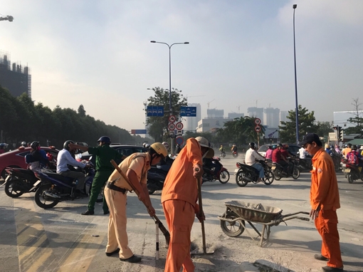 CSGT đẫm mồ hôi xúc đất cát vung vãi trên đường