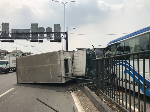 Sụp ổ gà, xe tải tông dải phân cách lật ngang rồi va chạm với xe khách
