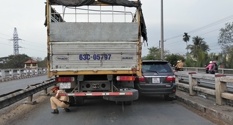 Xe tải kẹp chặt xe 7 chỗ trên cầu, 3 người thoát chết