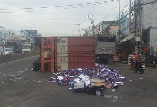 Xe container nổ bánh trước lật chắn ngang đường, hàng trăm thùng bia văng tung toé